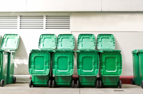 Operators loading waste into a skip with safety gear